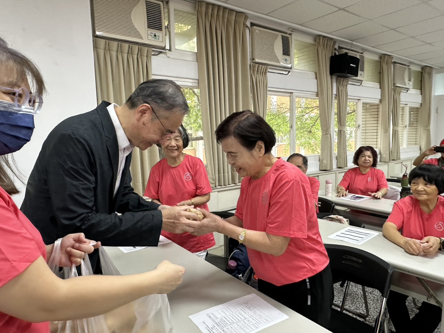 陳仁龍校長親贈樂齡學員「虎咬豬」特色美食，象徵「虎咬青春、咬住熱情」活力學習的精神。