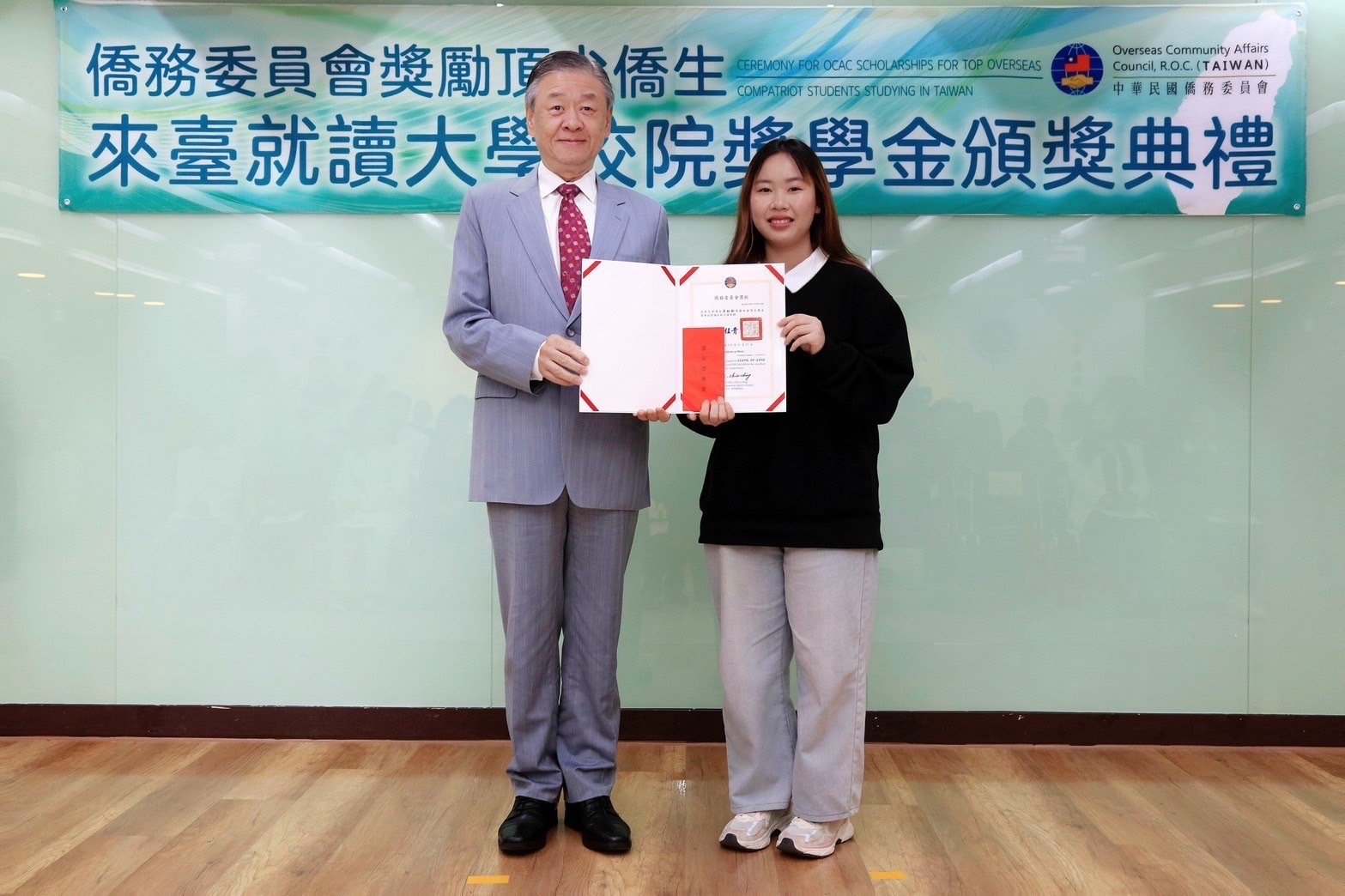由僑務委員會副委員長呂元榮(左)代表頒發獎學金。