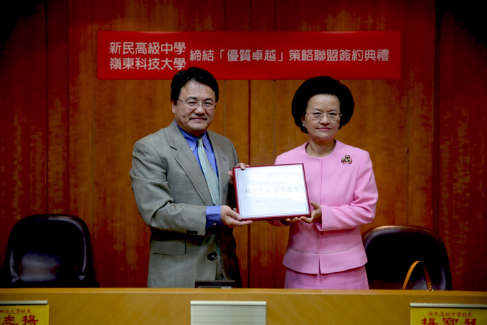 本校趙志揚校長（左）致贈新民高中楊寶琴校長（右） 「優質卓越 務實精進」紀念牌。